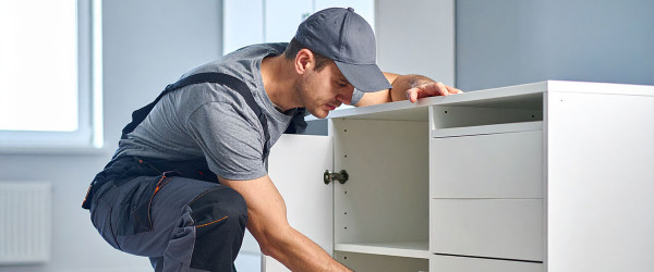 Ein Monteur, der einen Schrank montiert.