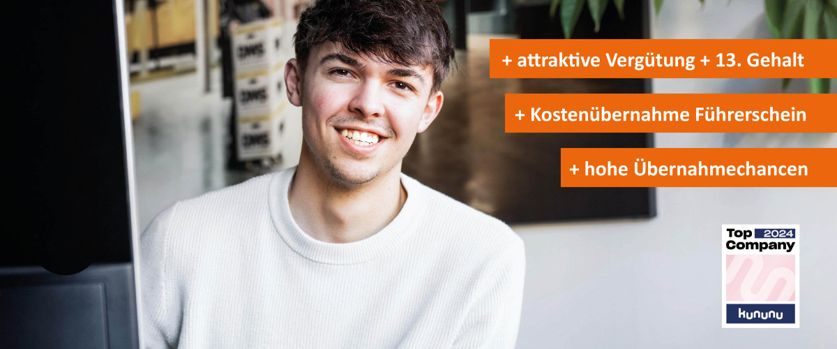 Mann der lächelnd vorm Computer sitzt.