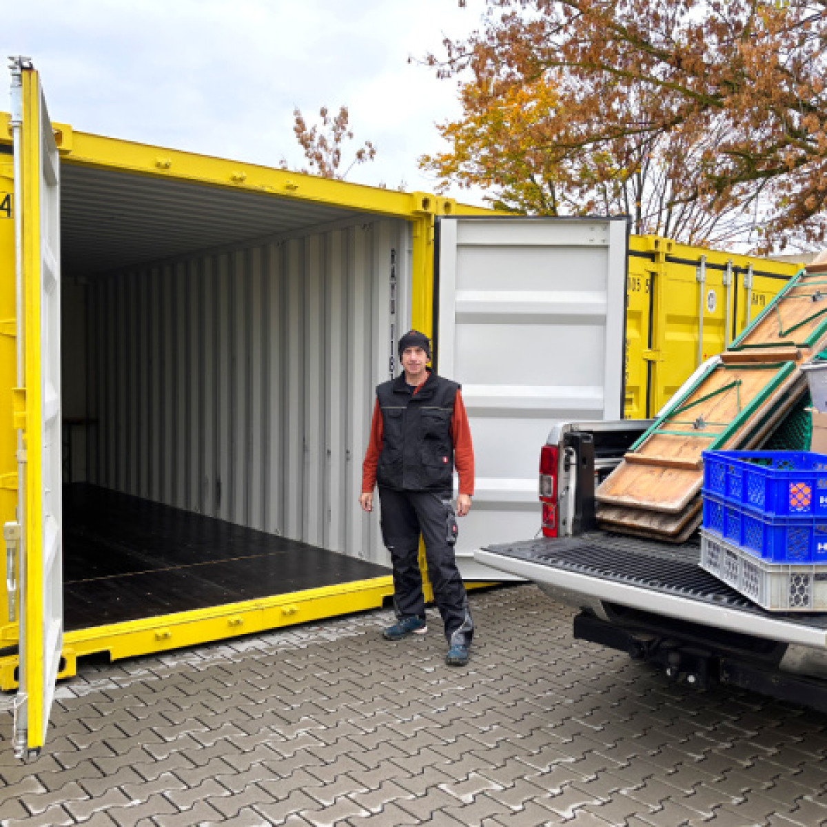 Mann der vor gelbem offenen Container steht
