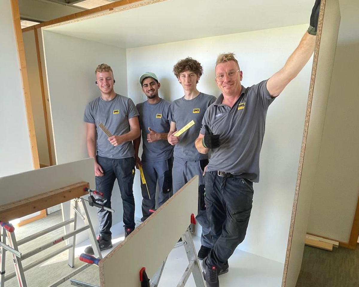 Männer in Arbeitskleidung, die lächeln.