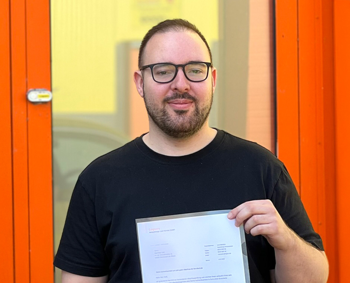 Mann der lächelt und sein Zeugnis hält