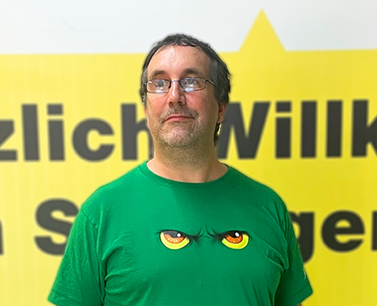 Mitarbeiter Thomas im SB-Lagerhaus vor Unternehmenshintergrund