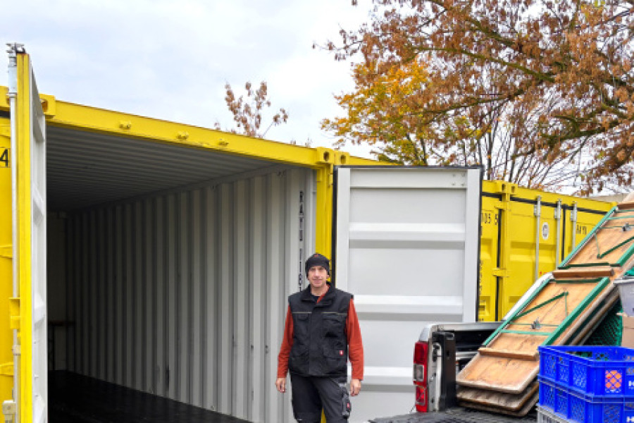 Mann der vor gelbem offenen Container steht