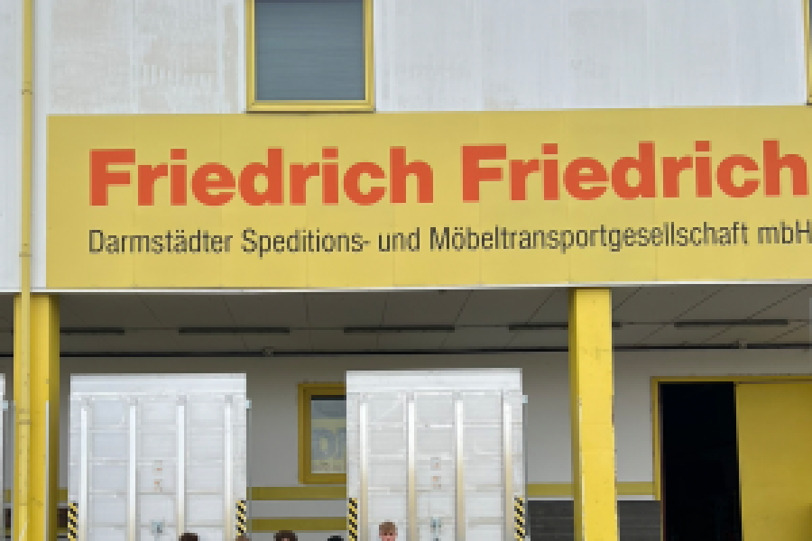 Azubis die vor dem Service Center stehen mit Geschenken in der Hand