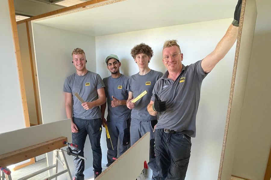 Männer in Arbeitskleidung, die lächeln.