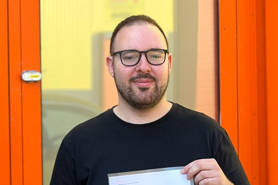 Mann der lächelt und sein Zeugnis hält